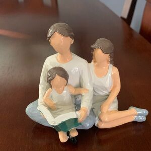 Figurine of mom and dad reading with daughter